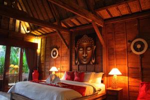 a bedroom with a bed with a large head on the wall at Ubud Virgin Villa in Ubud +143 photos