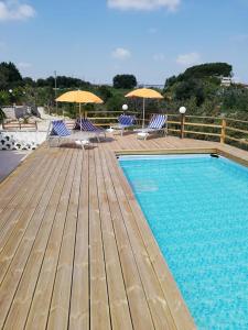 basen z leżakami i parasolami na tarasie w obiekcie Le Dimore Del Sarto rooms w mieście Polignano a Mare