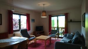 - un salon avec un canapé, des chaises et une table dans l'établissement Haus Schwalbennest, à Inzell