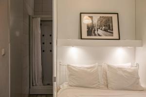 リスボンにあるCozy Studio in Central Bairro Altoのベッドルーム1室(白いベッド1台、上の写真付)