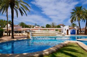 - une piscine avec une fontaine et des palmiers dans l'établissement El Retiro 29, à Dénia