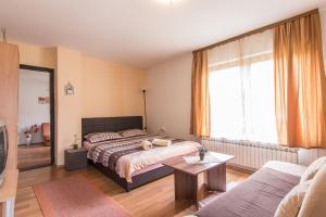 a bedroom with a bed and a living room at Guest House Kevser in Sarajevo