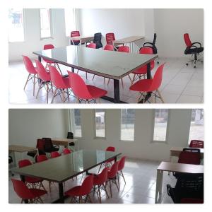 una sala de reuniones con mesas y sillas rojas en Uni Inn Semarang - Gunung Pati en Semarang