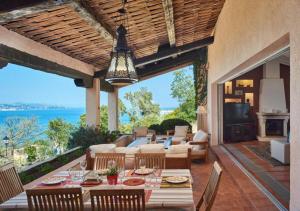 an outdoor patio with a dining table and a living room at Villa with Magic view of Bay of Saint Tropez in Saint-Tropez