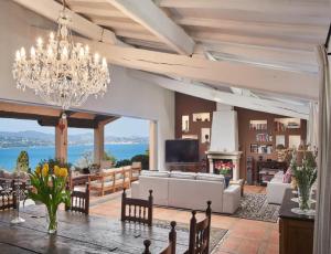 ein großes Wohnzimmer mit einem Kronleuchter und einem Tisch in der Unterkunft Villa with Magic view of Bay of Saint Tropez in Saint-Tropez