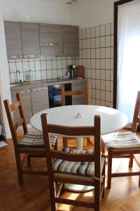 cocina con mesa blanca y sillas en una habitación en Monolocale nel Centro Storico di Sesto Calende, en Sesto Calende