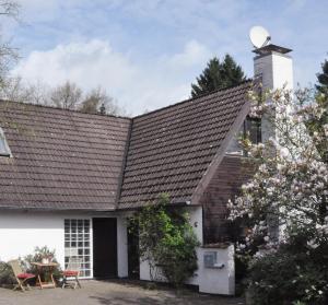 una casa con techo inclinado y chimenea en Atelierhaus Tannenweg, en Worpswede