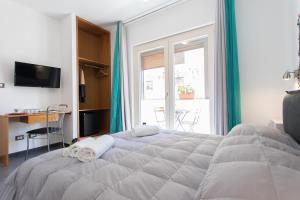a bedroom with a large bed with a desk and a window at My Way - Rooms - Palazzo San Matteo in Palermo