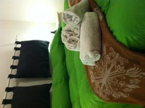 スコペッロにあるResidenza Biancaのベッド(緑のシーツ、タオル付)
