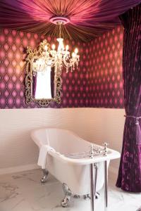 La salle de bains est pourvue d'une baignoire et d'un lustre. dans l'établissement Earl Of Doncaster Hotel, à Doncaster