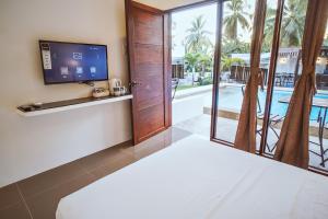 a living room with a tv and a sliding glass door at Quest Villa in Panglao Island