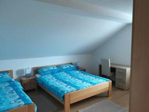 a bedroom with a bed with blue sheets and a desk at Natasa Apartments in Jezerce