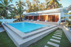 a swimming pool in the backyard of a house at Quest Villa in Panglao Island