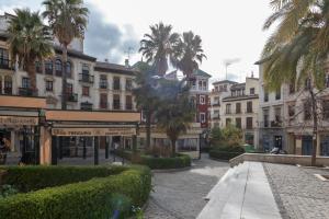 una calle en una ciudad con palmeras y edificios en San Jerónimo 17 Suites, en Granada