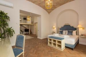 a bedroom with a king sized bed and a chair at Hotel Milton Roma in Rome