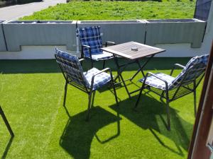 drie stoelen en een tafel op het gras bij Ferienwohnung Sinsheim-Dühren in Sinsheim