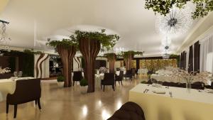 a dining room with tables and chairs and trees at Victoria Plaza in Pereslavl-Zalesskiy