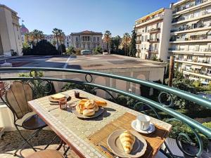 uma mesa com um prato de comida numa varanda em Nestor&Jeeves - SUITE FLORA - Promenade des Anglais - Central em Nice