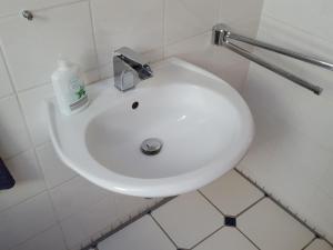 a white bathroom sink with a soap bottle on it at Ferienwohnung Sinsheim-Dühren in Sinsheim