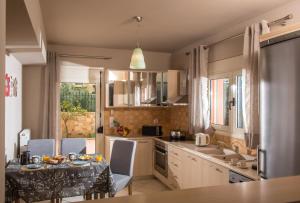 a kitchen with a table and some chairs and a table and a sink at Sunshine Koutouloufari in Hersonissos +25 photos