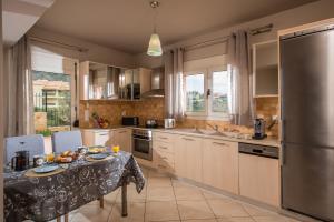 a kitchen with a table and a stainless steel refrigerator at Sunshine Koutouloufari in Hersonissos