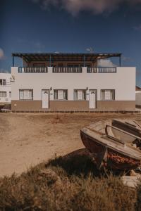 ein Boot, das vor einem Gebäude sitzt in der Unterkunft La Pardela Excellence Apartamentos in Caleta de Sebo