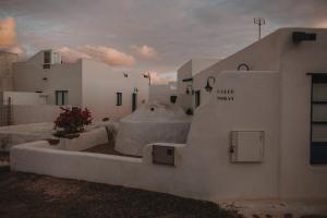 a group of white buildings with flowers in a courtyard at La Pardela Excellence Apartamentos in Caleta de Sebo