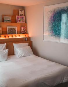 a bedroom with a bed, desk, and painting on the wall at Le Citizen Hotel in Paris
