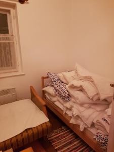 Un dormitorio con una cama sin hacer y una ventana en Folyóka Vendégház, en Egyházasgerge