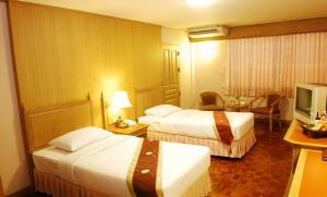 a hotel room with two beds and a television at Silom Village Inn in Bangkok +19 photos