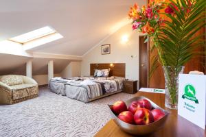 ein Hotelzimmer mit einem Bett und einer Obstschale auf dem Tisch in der Unterkunft Family Hotel Romantika in Welingrad