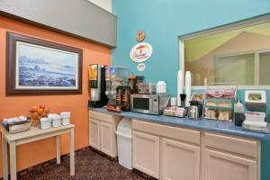 a coffee shop with a counter with food and drinks at Super 8 by Wyndham Belleville St. Louis Area in Belleville