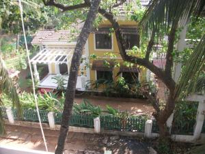 a house with a fence in front of it at Shalom Guest House in Candolim