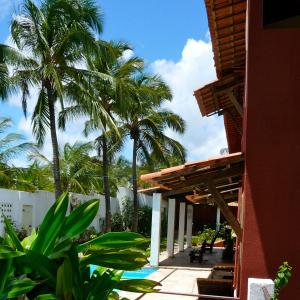 a resort with palm trees and a building with a patio at Casa Cohiba in Cumbuco +14 photos