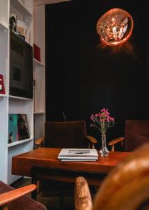 einen Esstisch mit einer Blumenvase darauf in der Unterkunft Le Citizen Hotel in Paris