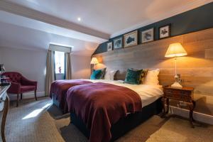 um quarto de hotel com uma cama grande e uma cadeira em The Foley em Claygate