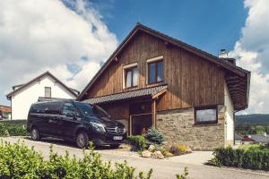 a black van parked in front of a house at Residence Lipno in Lipno nad Vltavou