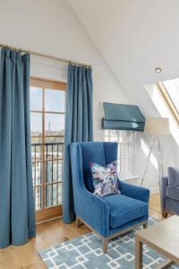 a blue chair in a living room with a window at Destiny Scotland - Royal Mile Residence in Edinburgh