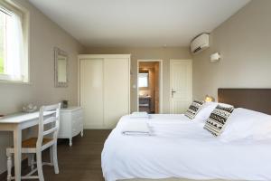 ボニューにあるLes Terrasses du Luberonの大きな白いベッドと机のある寝室 +41枚の写真