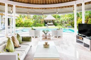a living room with a couch and a tv at Villa Bliss a paradise of three independent Villas in Canggu