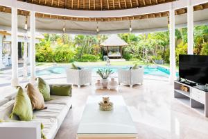 a living room with a couch and a tv at Villa Bliss a paradise of three independent Villas in Canggu