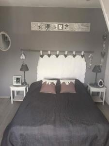 a bedroom with a large bed with two pillows at Cosy Maison Honfleur in Honfleur