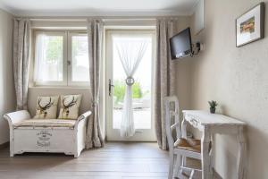 ボニューにあるLes Terrasses du Luberonの窓、椅子、テーブルが備わる客室です。