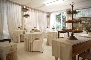 a room with white tables and white chairs and a room with windows at Locanda A Cà Du Gigante in Monterosso al Mare