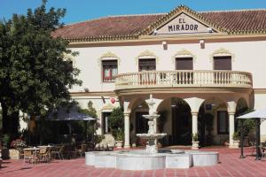 un bâtiment avec une fontaine devant lui dans l'établissement Hotel El Mirador, à Alhaurín el Grande