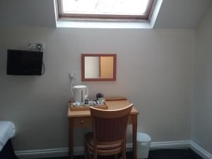 a desk with a mirror and a sink in a room at The Prince Consort in Southampton
