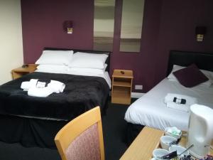 a hotel room with two beds and a table at The Prince Consort in Southampton