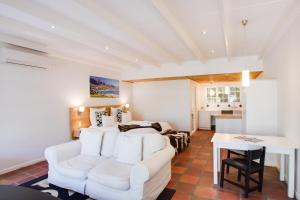 a living room with a white couch and a table at Albourne Guesthouse in Somerset West