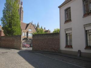 een stenen muur met een poort voor gebouwen bij Bonobo Apartments in Brugge