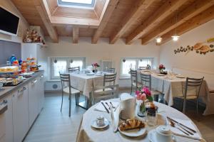 kuchnia i jadalnia ze stołami i krzesłami w obiekcie B&B La Casa di Rosa w mieście Vago